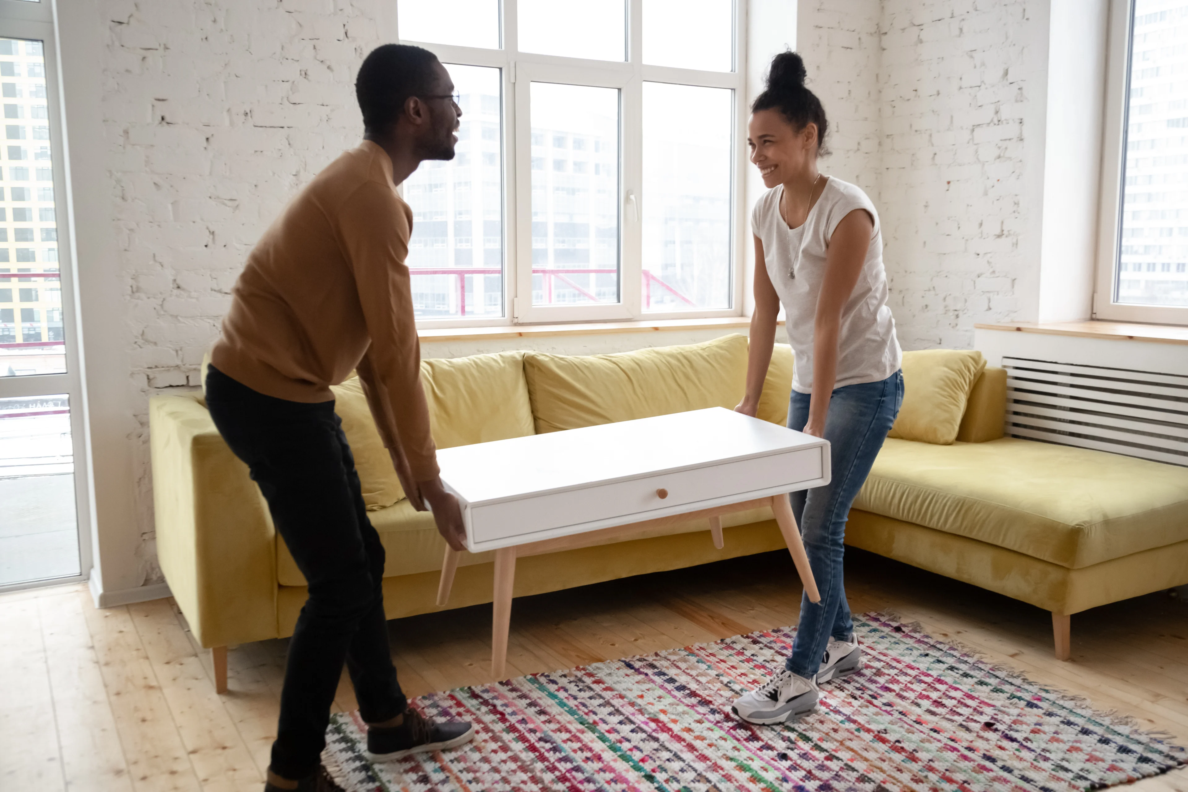 two people moving a coffee table in a living room