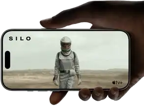 A hand holds an iPhone 17 Pro, Silver, horizontal, video playback on all-screen display demonstrating battery life