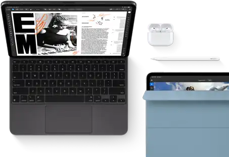 iPad Pro attached to Magic Keyboard, front exterior, space black colour, rounded corners, black display bezel, open, display showing article editing app with text and photograph of a woman playing music, Airpods 4 in open case, blue Smart Folio cover on iPad Pro with Apple Pencil Pro resting atop device, cover slightly open revealing display