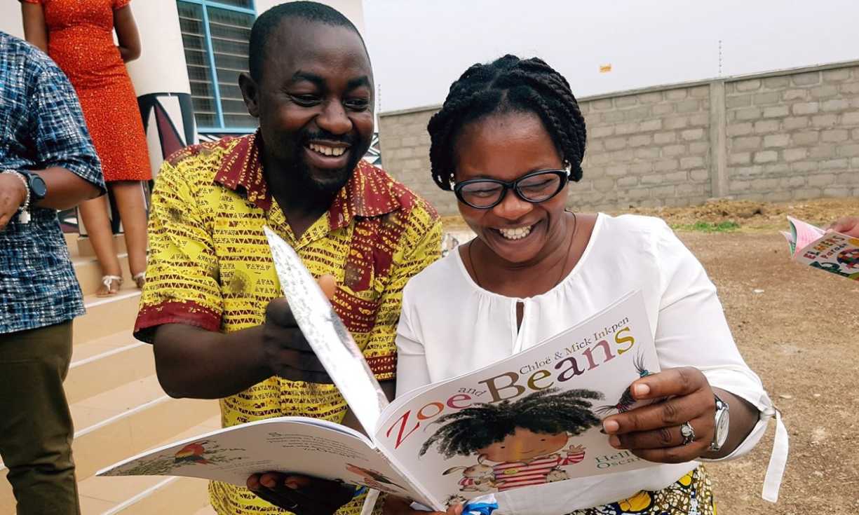 AfriKids staff excitedly unpack a book after unloading a shipment from Book Aid International in Northern Ghana