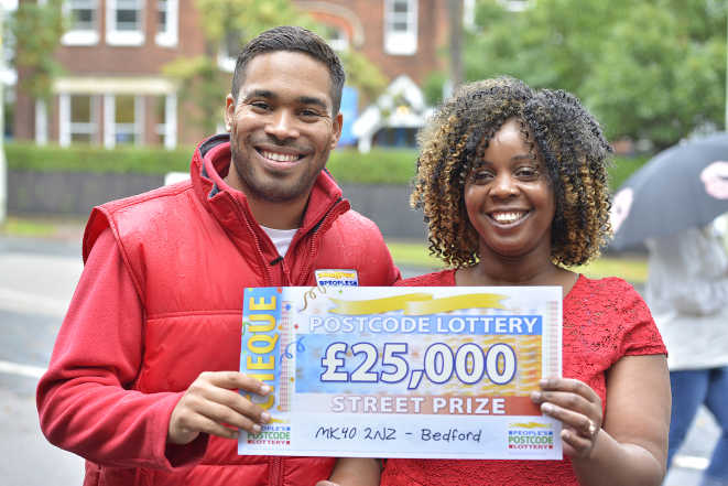 People's Postcode Lottery presenter Danyl Johnson and Bedford player Shirley proudly display her £25,000 cheque