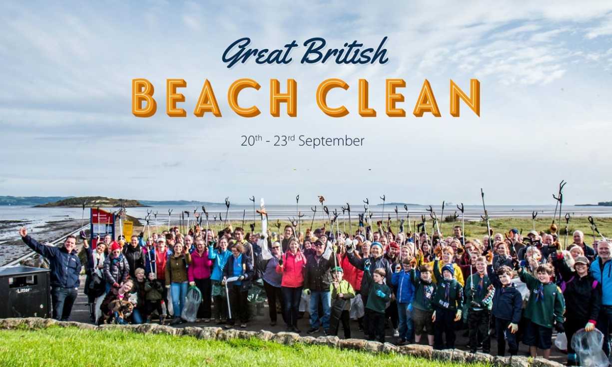 Volunteers at a Marine Conservation Society Great British Beach Clean event hold their pickers aloft