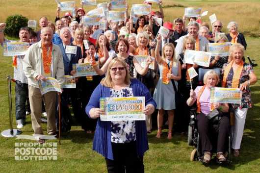 Liz Campbell and other lucky European Postcode Millions winners in Troon celebrating with their cheques