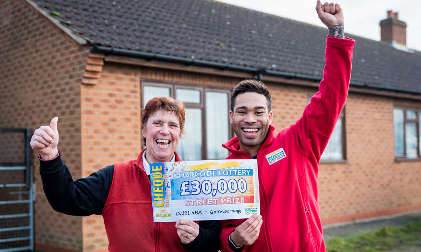 Lilian looking ecstatic with her £30,000 cheque and Street Prize Presenter Danyl Johnson