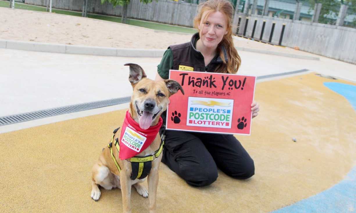 A Dogs Trust canine and staff member show their gratitude to players of People's Postcode Lottery