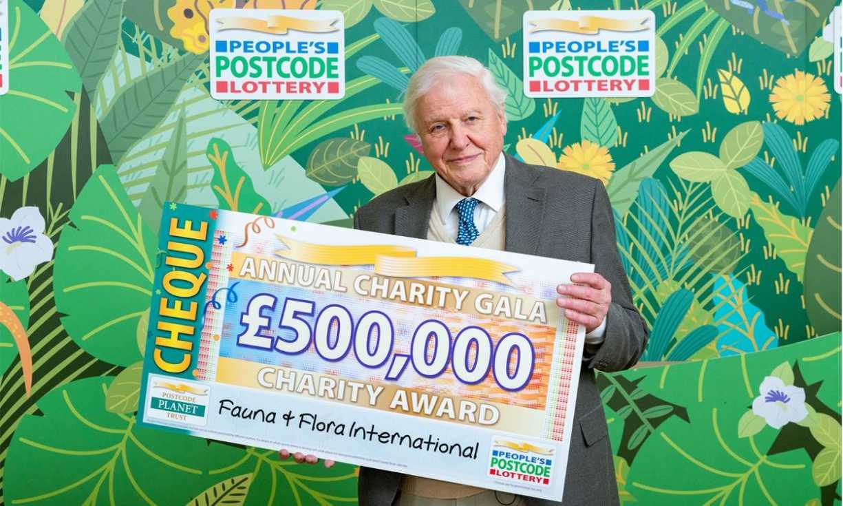 Sir David Attenborough with a £500,000 cheque for Fauna & Flora International