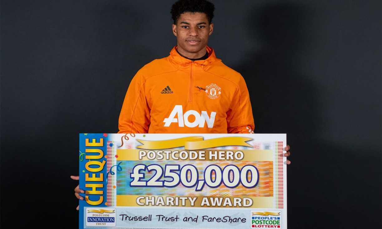Postcode Hero Marcus Rashford MBE with a £250,000 cheque, raised by our players, for the Trussell Trust and FareShare