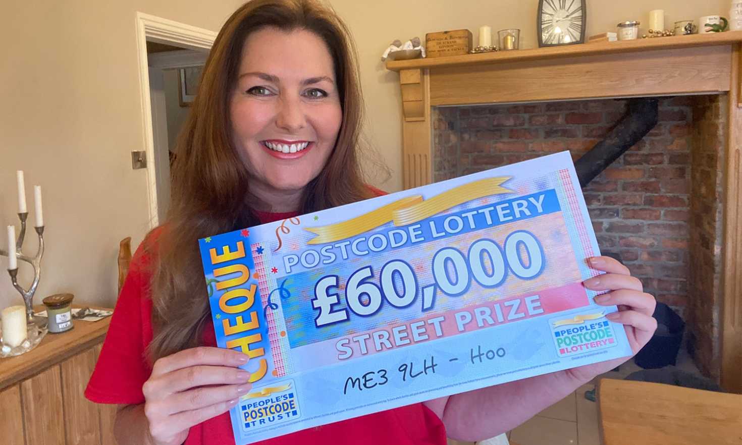 Judie with a cheque for our Hoo winner who picked up £60,000 thanks to playing with two tickets!
