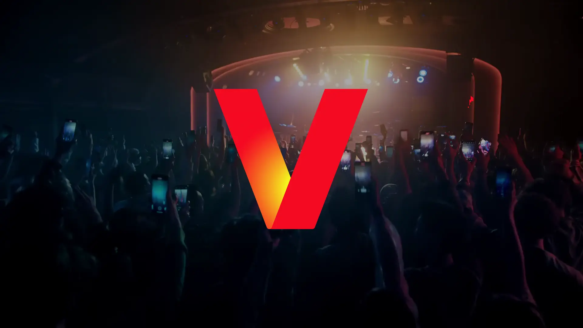 The new Verizon logo over a crowd of people at a concert.