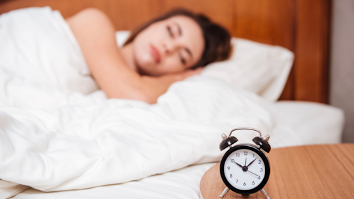 Girl in bed and alarm clock