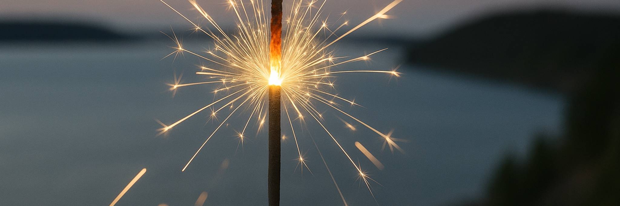 Fireworks light up the sky over a forested lakeshore, with a modern wooden house and terrace in the foreground overlooking the water.