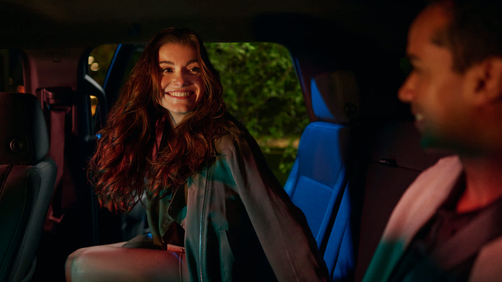 Smiling passenger entering a Lyft ride with a friend already in the car. 