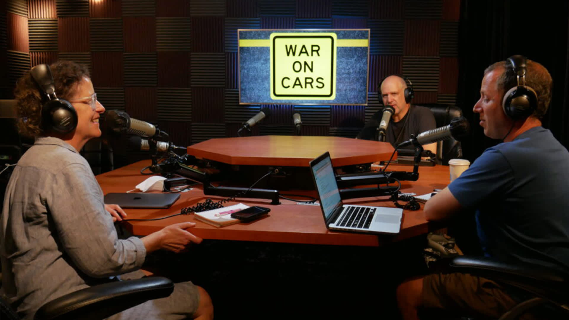 Hosts of The War on Cars in their studio. From left to right, Sarah Goodyear, Aaron Naparstek, and Doug Gordon. (Image Credit: The War on Cars)