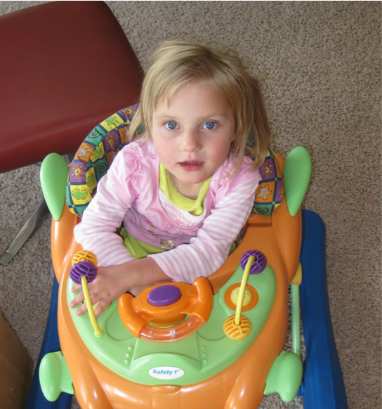 Child living with Rett syndrome at 6-18 months playing in toddler walker
