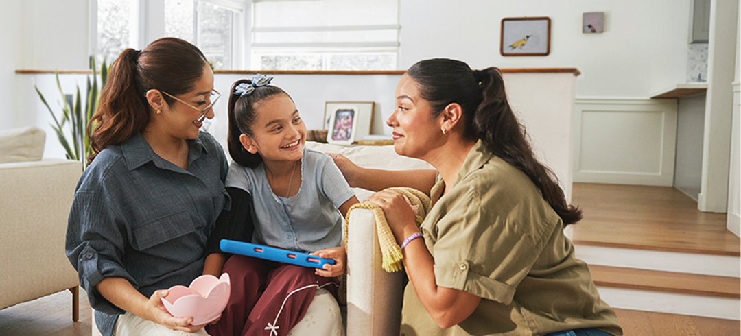 Two women and a child with Rett syndrome use a Tobii device