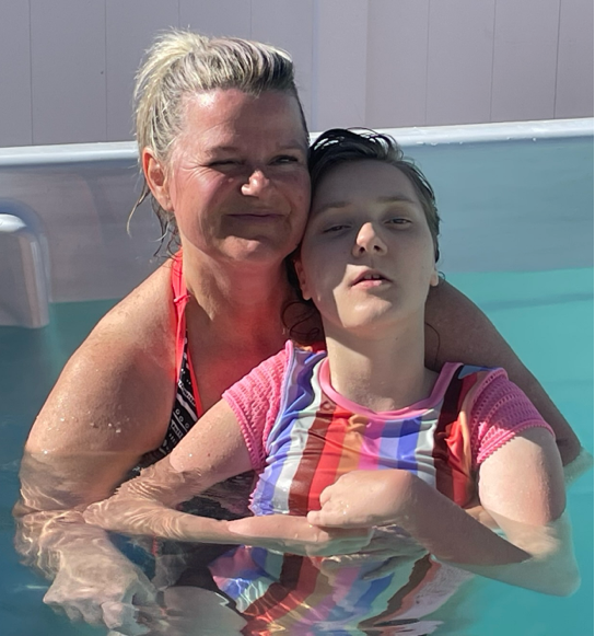 Child living with Rett syndrome at 10+ years old swims in the pool with her mom