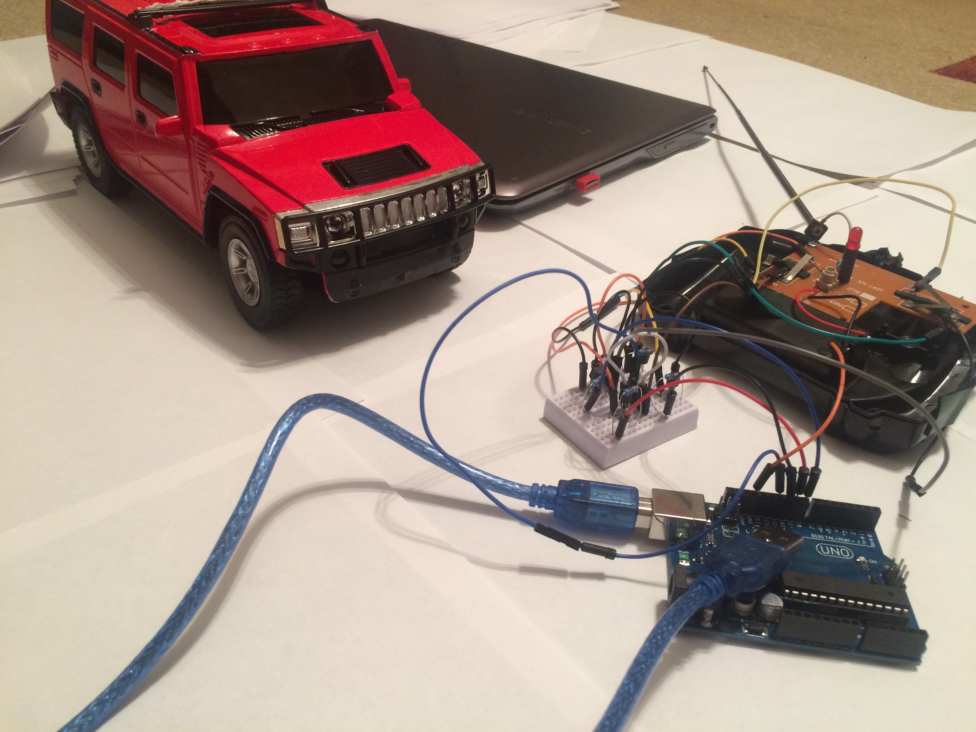 Red Hummer and disassembled radio control connected to Arduino