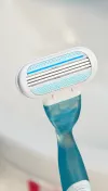 Rasoir rechargeable de couleur bleu foncé Venus de Gillette avec un focus sur la tête de rasoir et les 3 lames