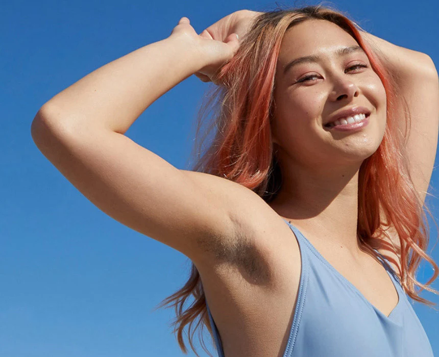 Femme souriant avec un ciel clair en arrière-plan