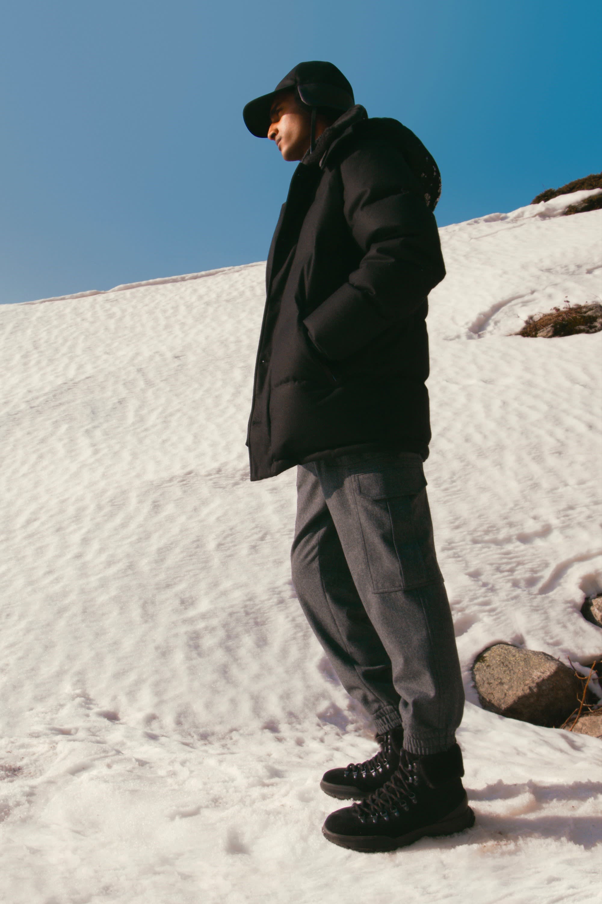 Brioni model wearing earflop cap and quilted jacket from the Mountain Capsule