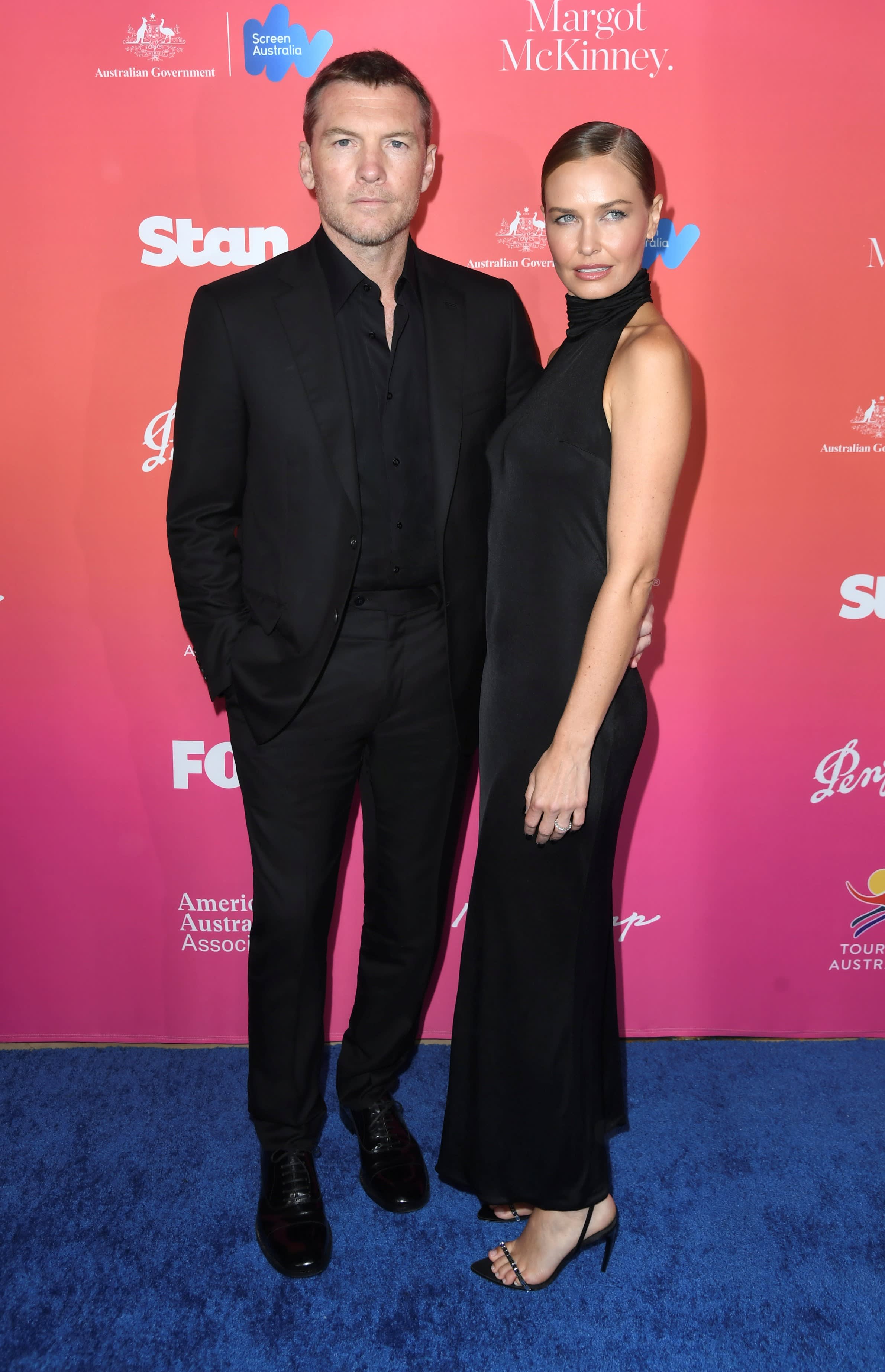Sam Worthington, pictured with wife Lara Worthington, wearing a Brioni black suit