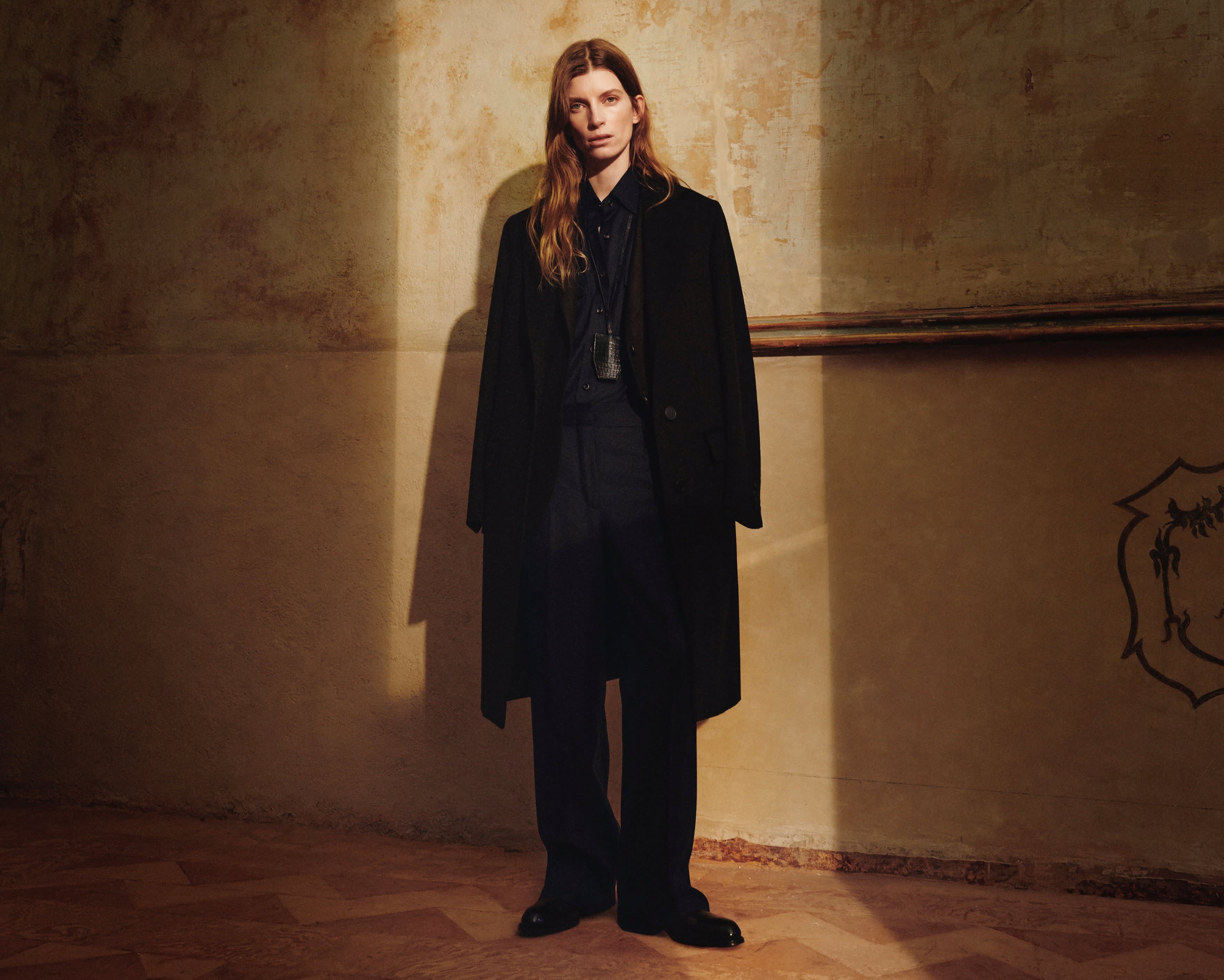 Woman model wearing black coat from Brioni capsule collection