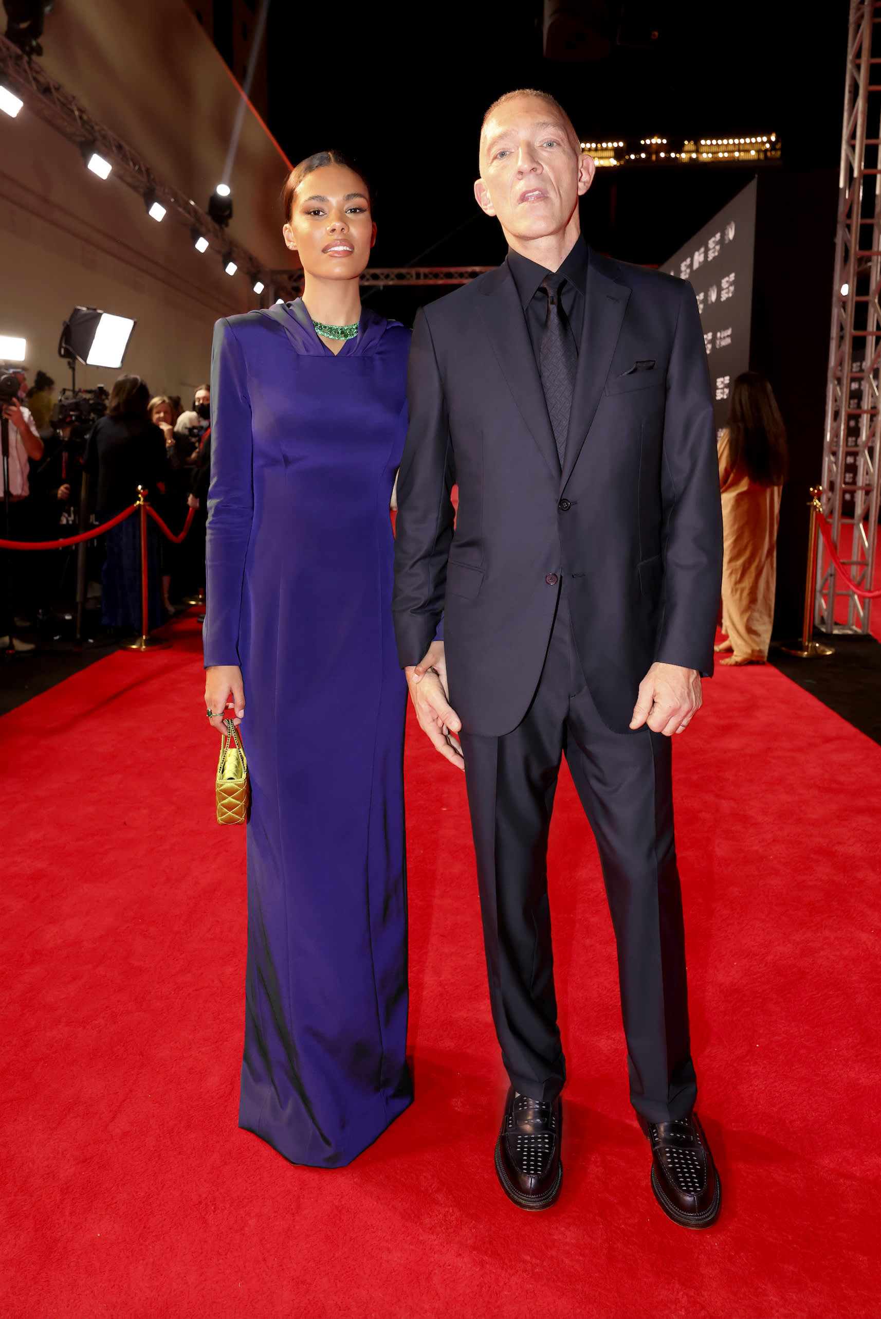 Vincent Cassel, pictured with Tina Kunakey, wearing a Brioni blue suit