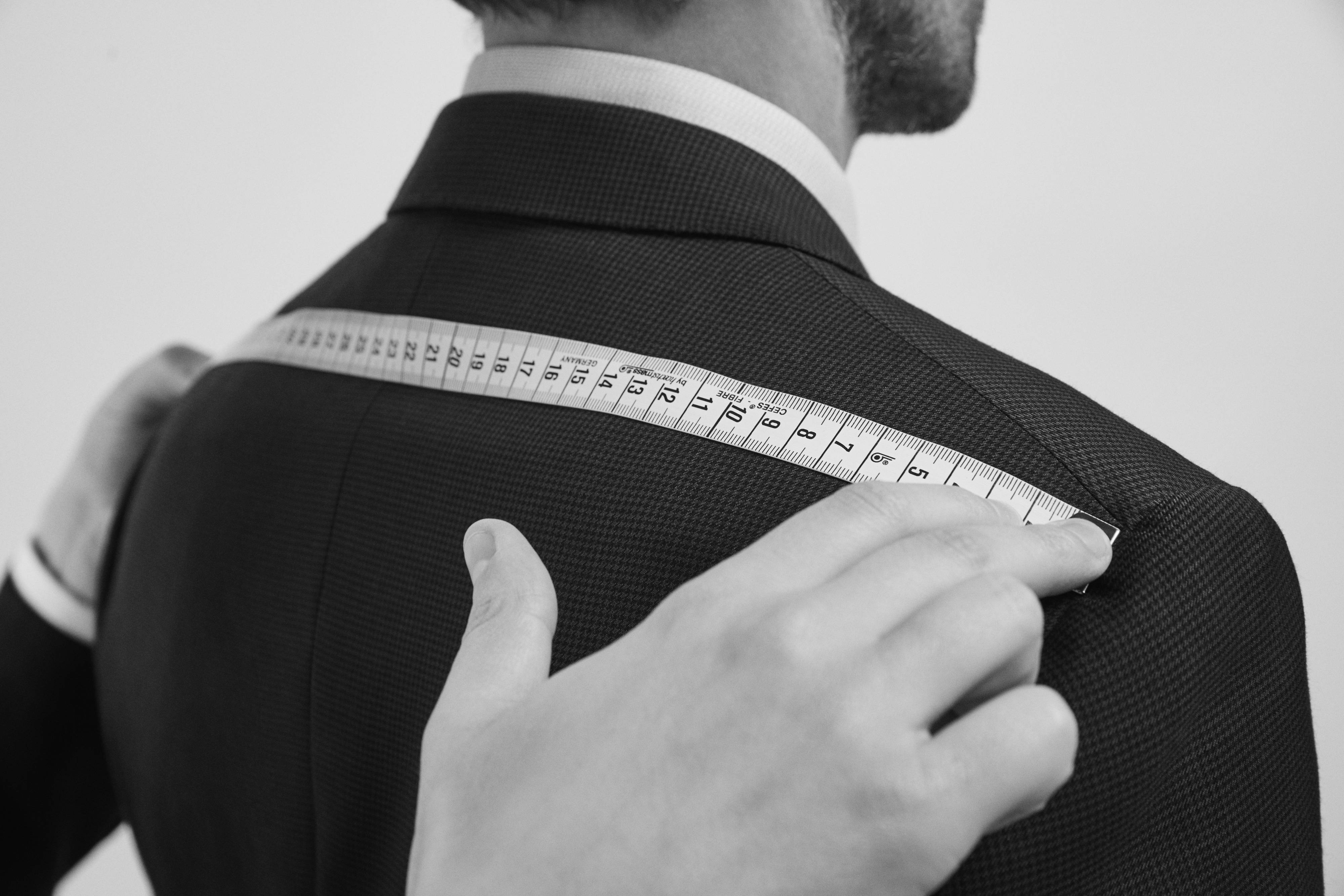 A Brioni master tailor taking the measurements of a client