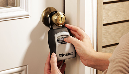 woman operating a master lock 5400D Lockbox on a door knob