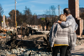 couple looking at wildfire damage