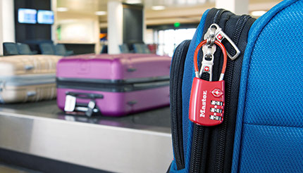 Master Lock 4696D red padlock attached to a suitcase