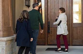 A realtor walking up to a door with a lock box