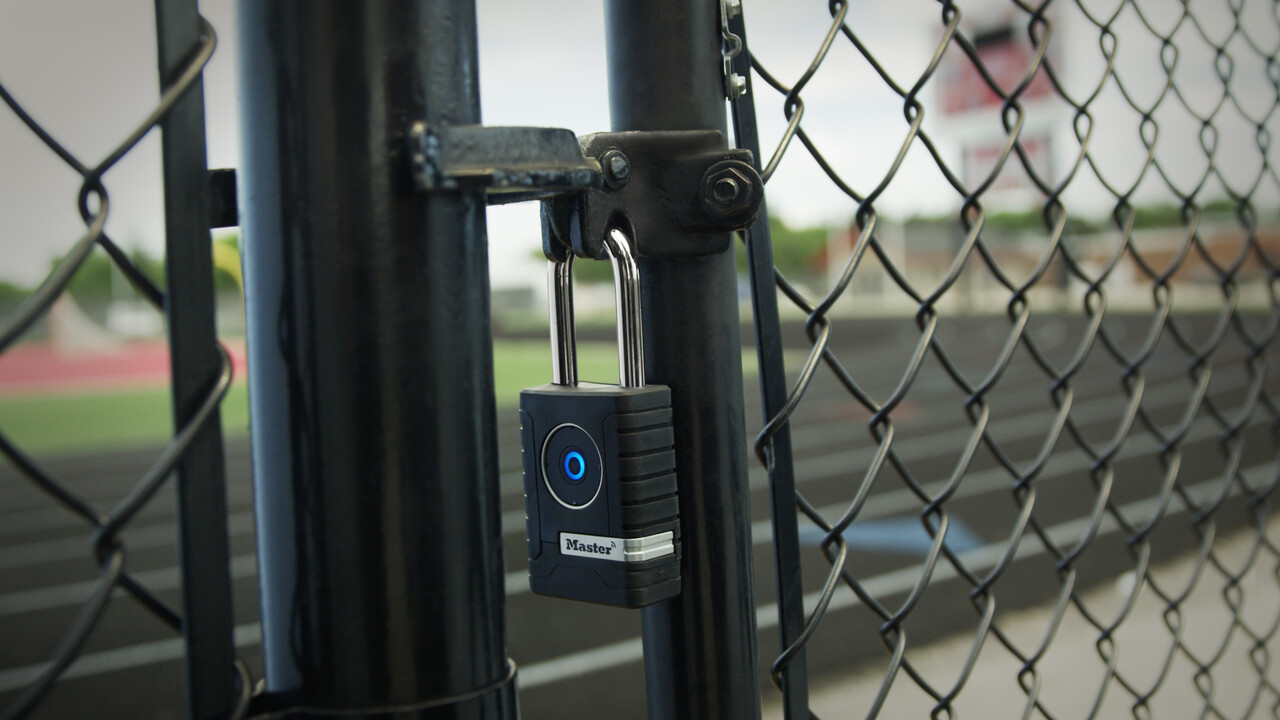 A Bluetooth padlock on a fence at a sports complex