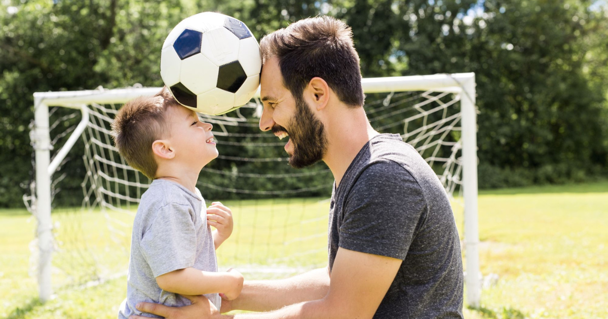 Папы играют в футбол. Папа и сын футбол. Фотосессия на футбольном поле с сыном. Футбольная семья. Отец играет с сыном.