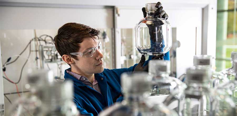 Scientist looking at glass jar