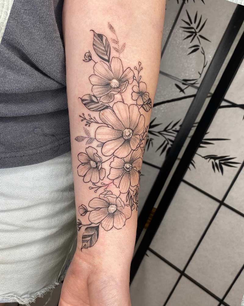 Fine line flower tattoo on the inner forearm
