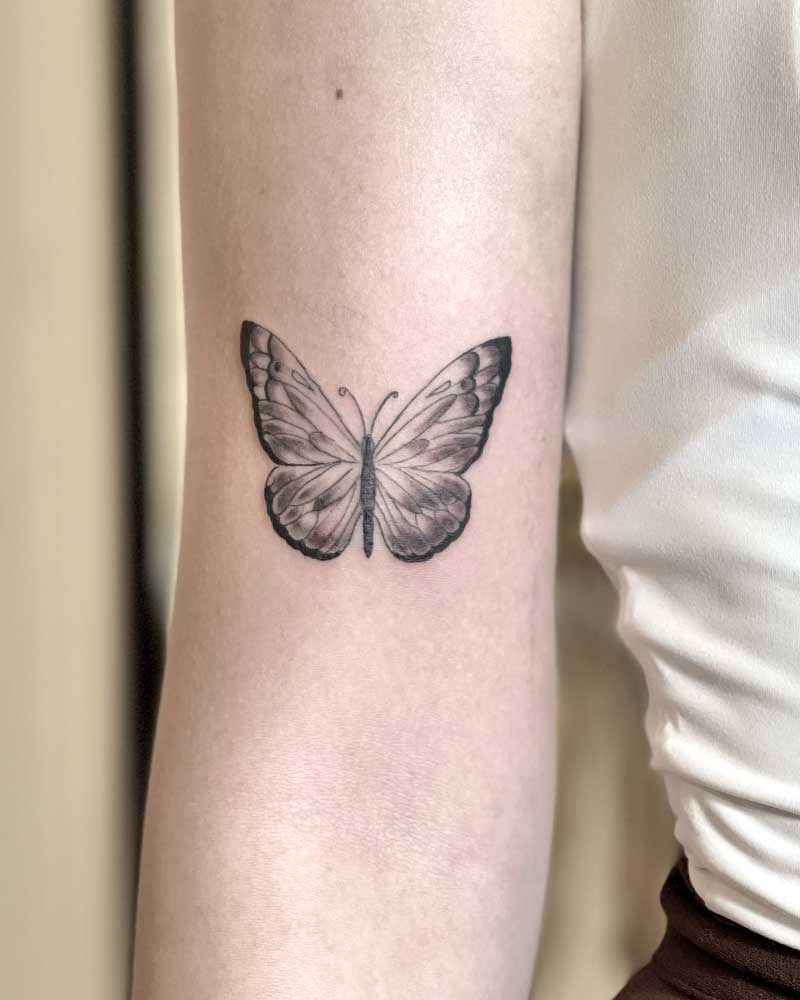 Fine-line butterfly tattoo 