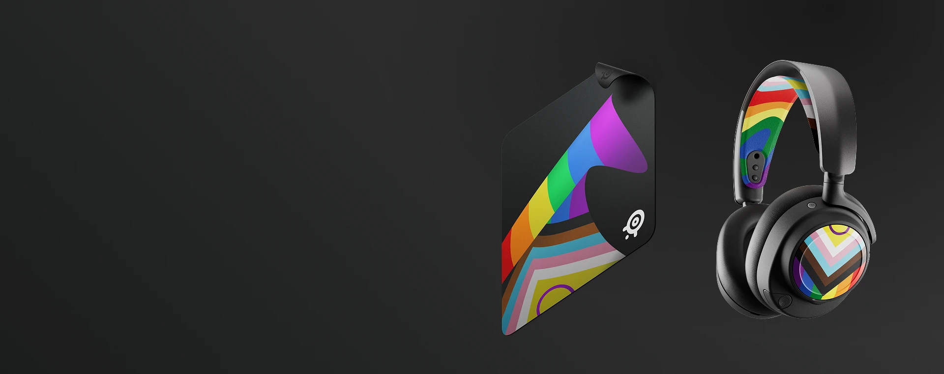 SteelSeries QcK cloth gaming mouse pad and wireless headset from the 2026 Pride collection with rainbow flag details.