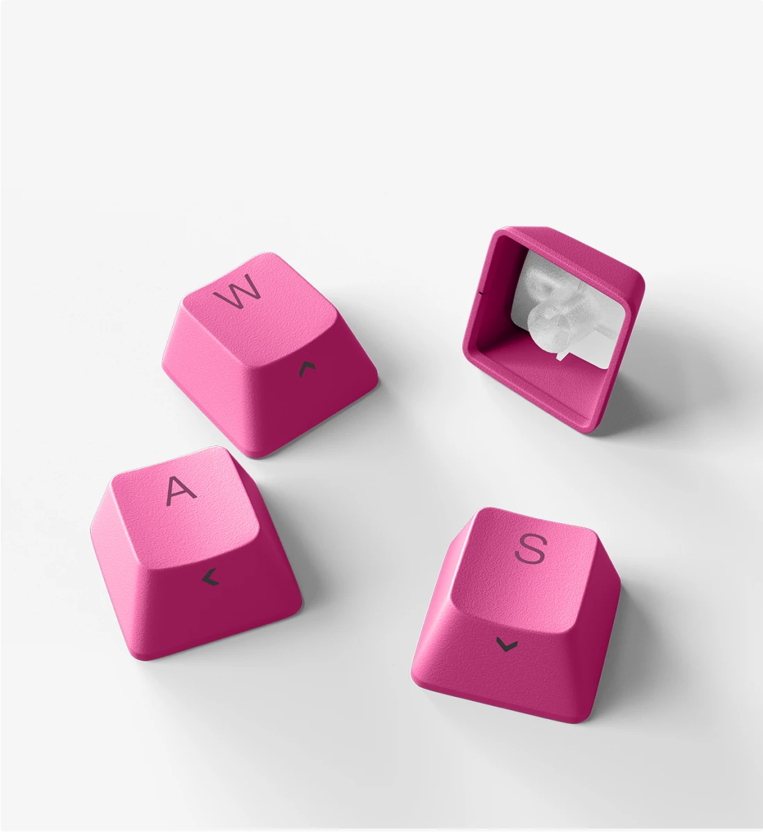 Four vibrant pink custom keycaps, including the WASD directional keys for gaming, on a white background.