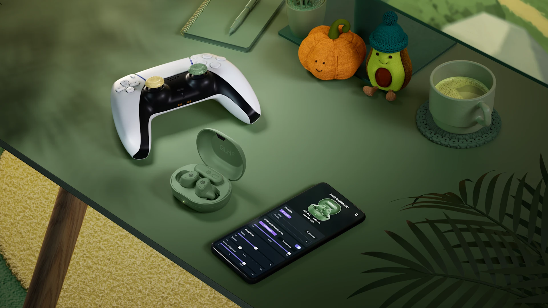 Matcha green SteelSeries Arctis GameBuds charging case on a desk next to a mobile phone with companion app and a PlayStation 5 controller featuring KontrolFreek thumbsticks.