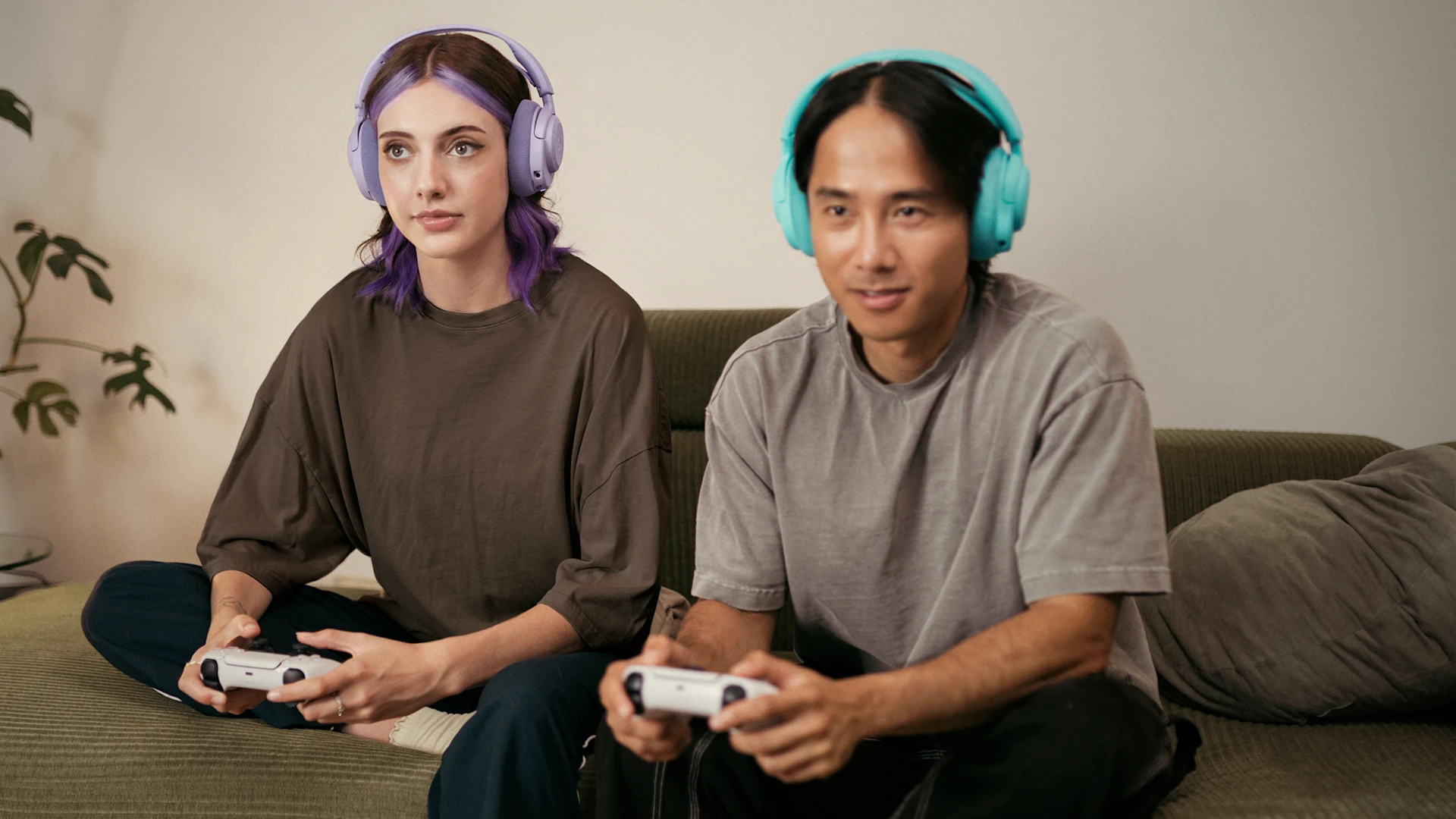 2 people with headphones on play on console