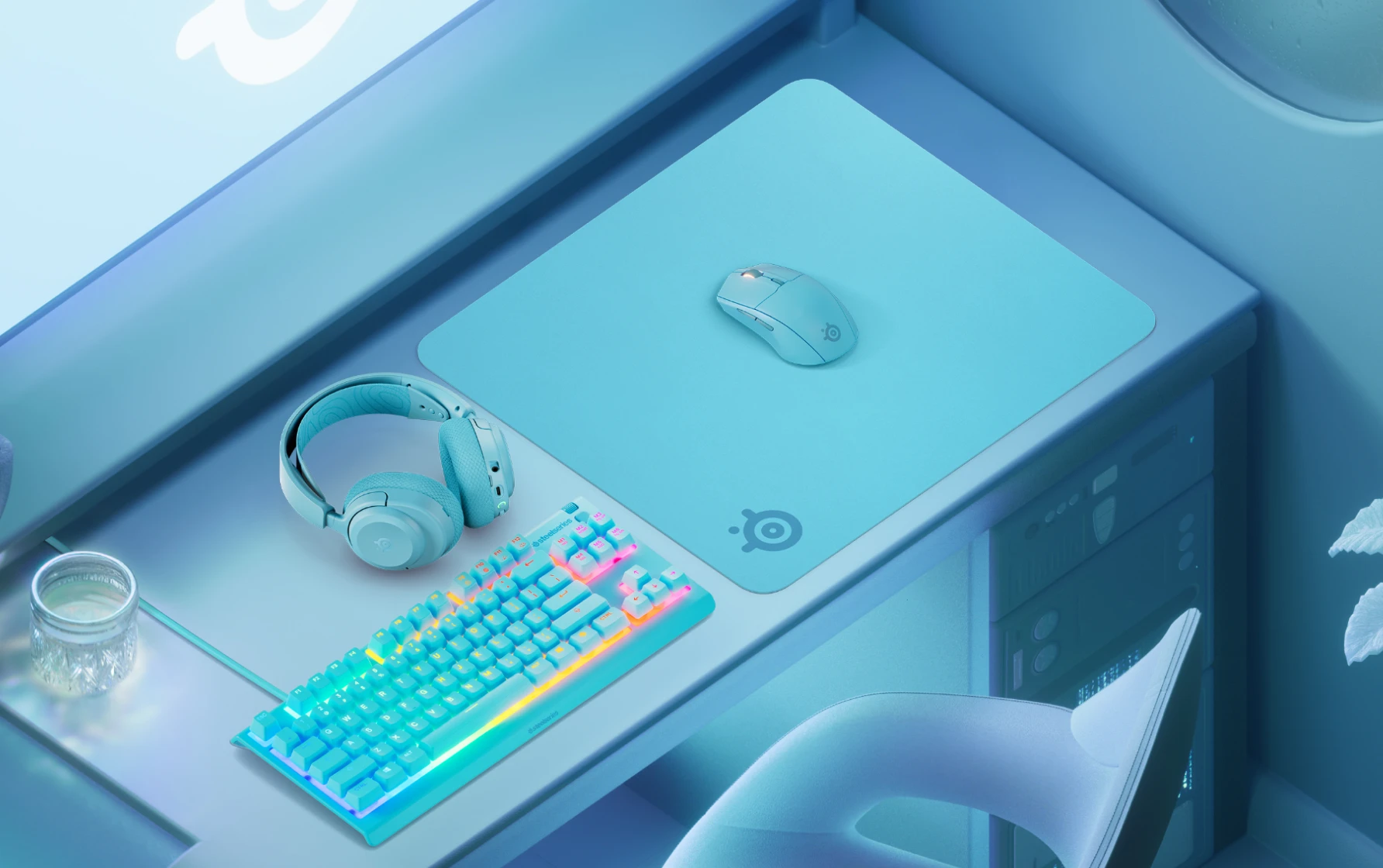 Una elegante configuración de juego en azul claro con un teclado RGB a juego, un ratón, una alfombrilla SteelSeries y unos auriculares dispuestos de forma ordenada sobre un escritorio.