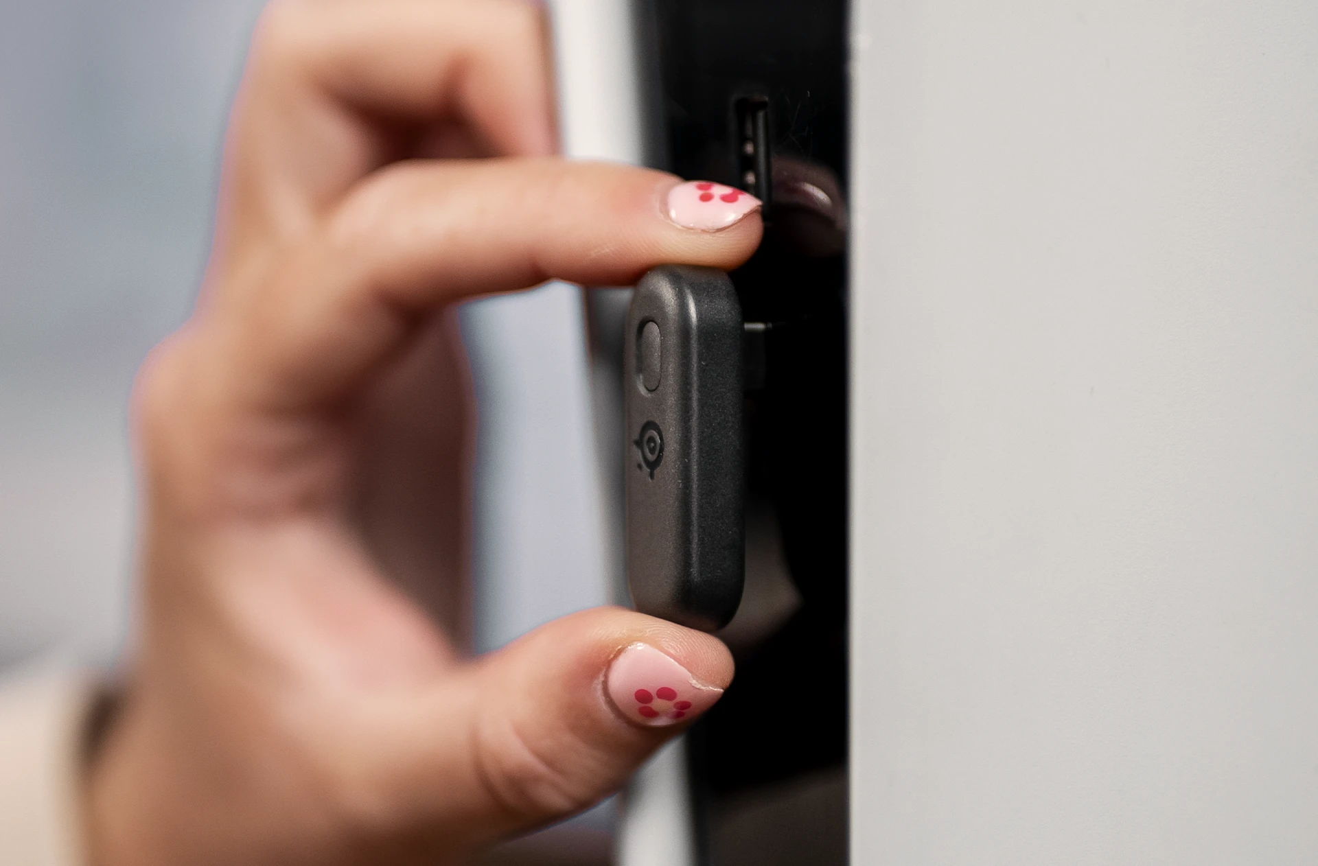 A hand is plugging in a dongle to PlayStation console.