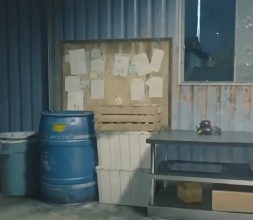 A brown board with notes on it, laying against a blue ish metal container.