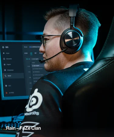 A player from the FaZe clan sitting in front of a computer with Arctis Nova Pro Wireless Black headphones on his head.