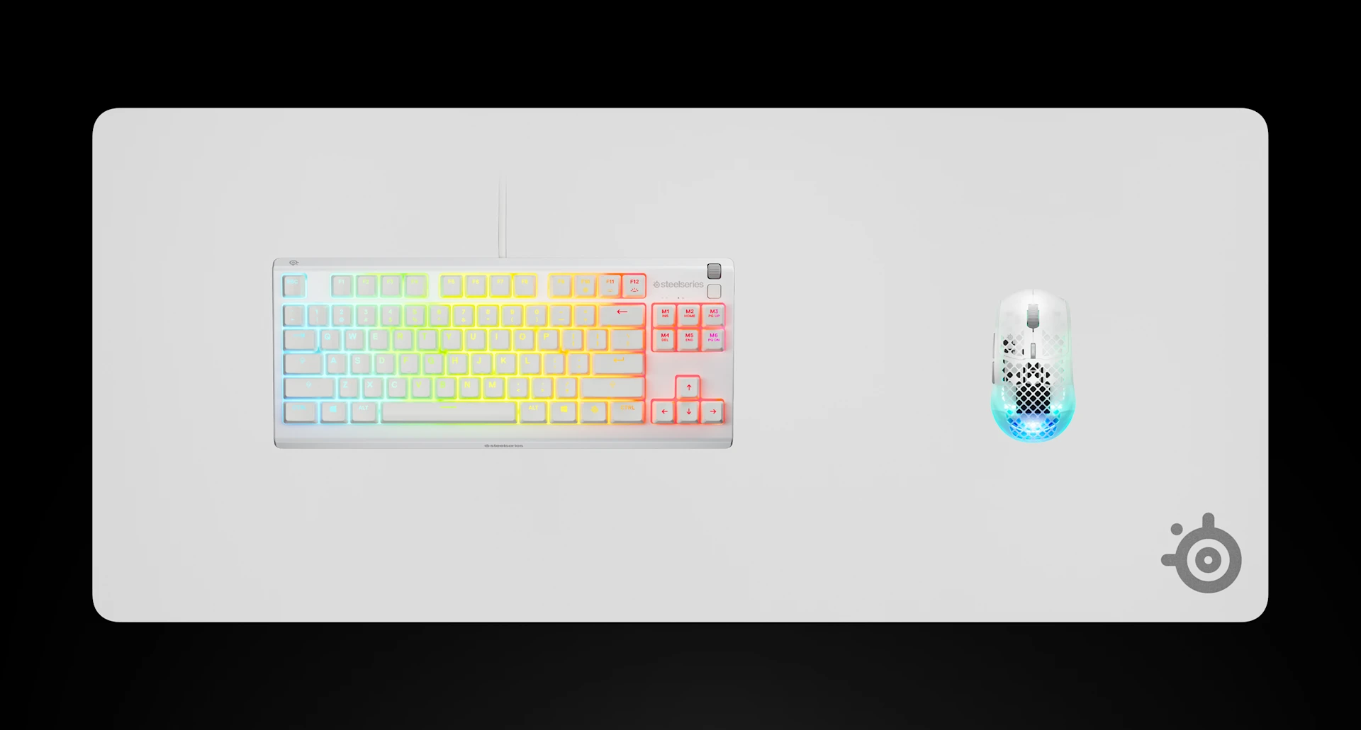 Top-down view of a white SteelSeries QcK Heavy XXL gaming mousepad featuring an RGB mechanical keyboard and a white Aerox gaming mouse.