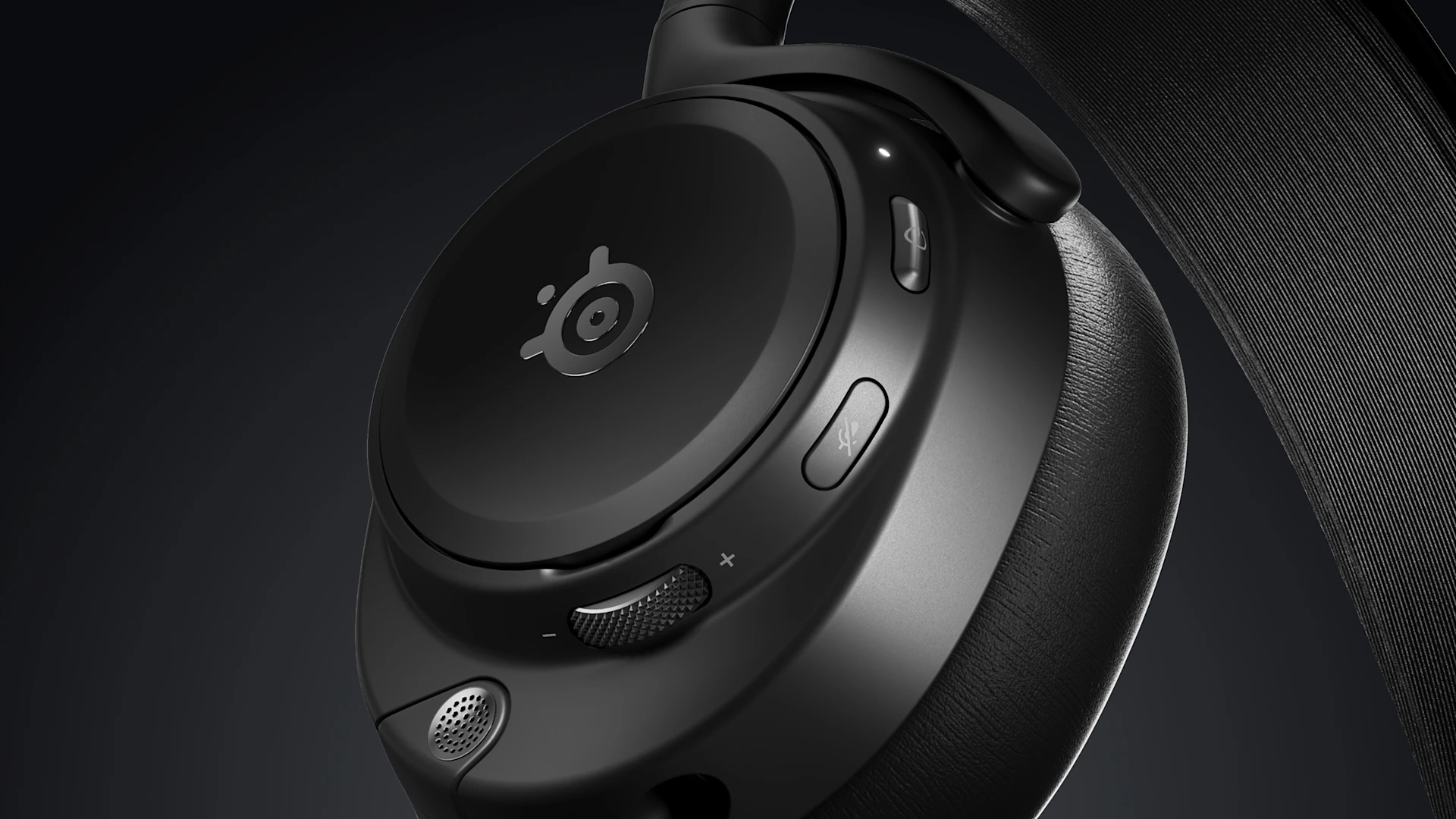 Detailní záběr na sluchátka SteelSeries s logem, tlačítky pro ztlumení a ANC, kolečkem pro nastavení hlasitosti a malým mikrofonem na tmavém texturovaném pásku.