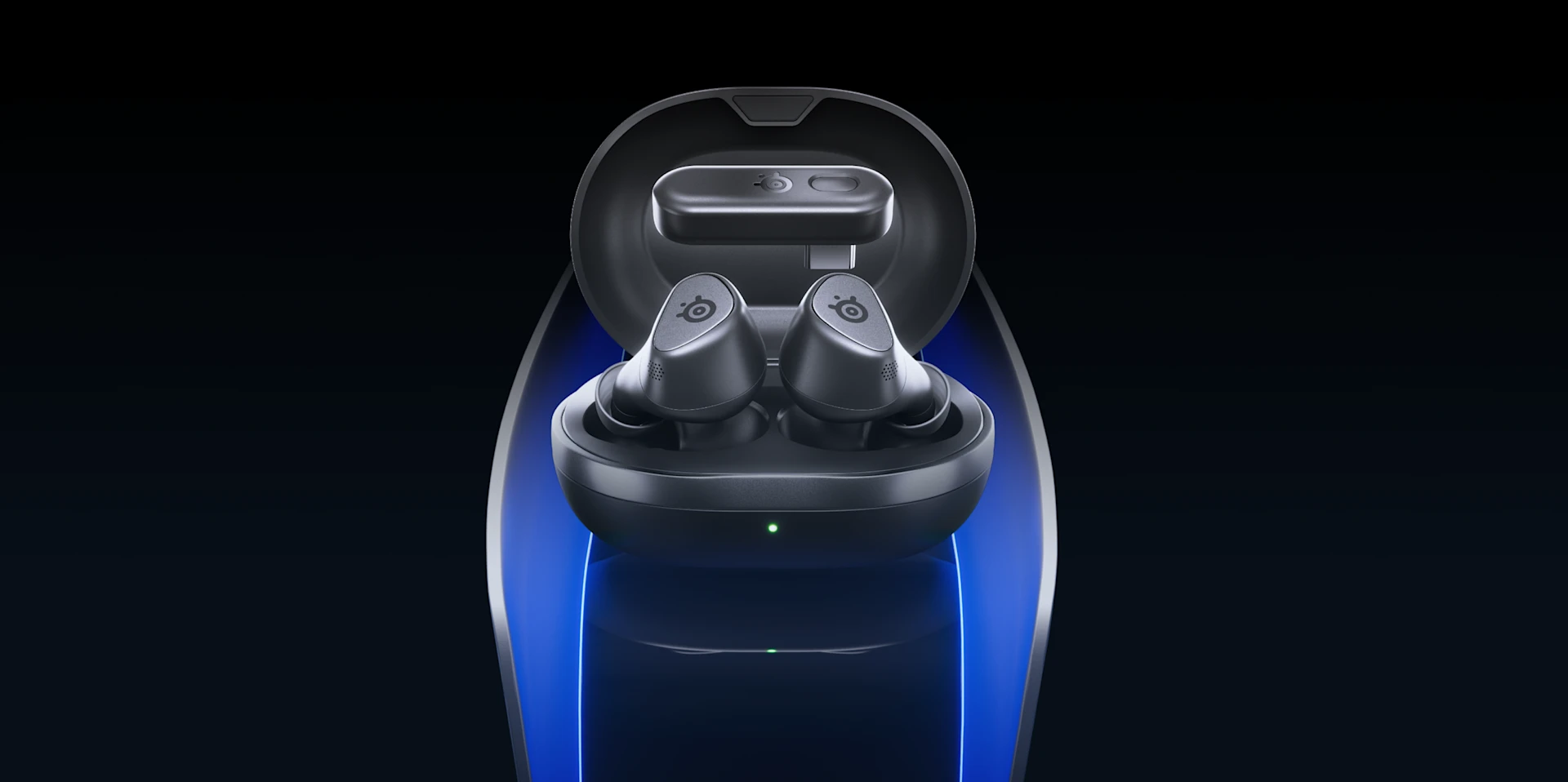View of the black Arctis Gamebuds headphones lying in a black charging case; the dongle is hovering slightly above the headphones; everything is set against a black background with blue stripes on the sides.
