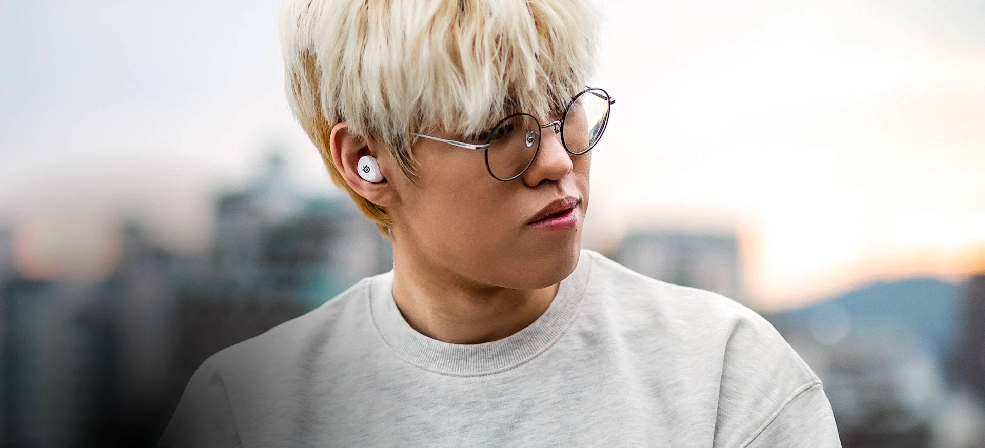 Jogador T1 usando Arctis Gamebuds brancos.