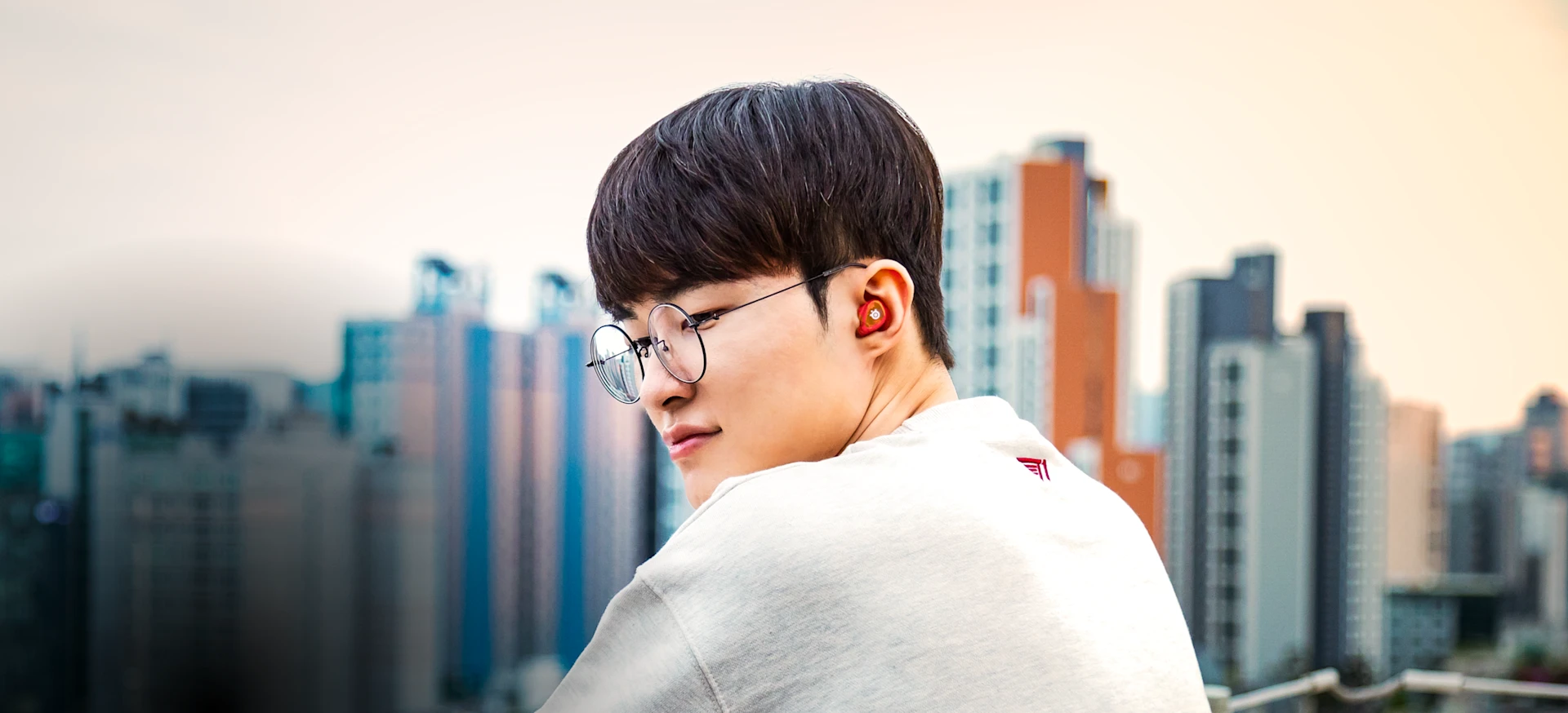 Jogador T1 Faker usando Gamebuds Arctis pretos.